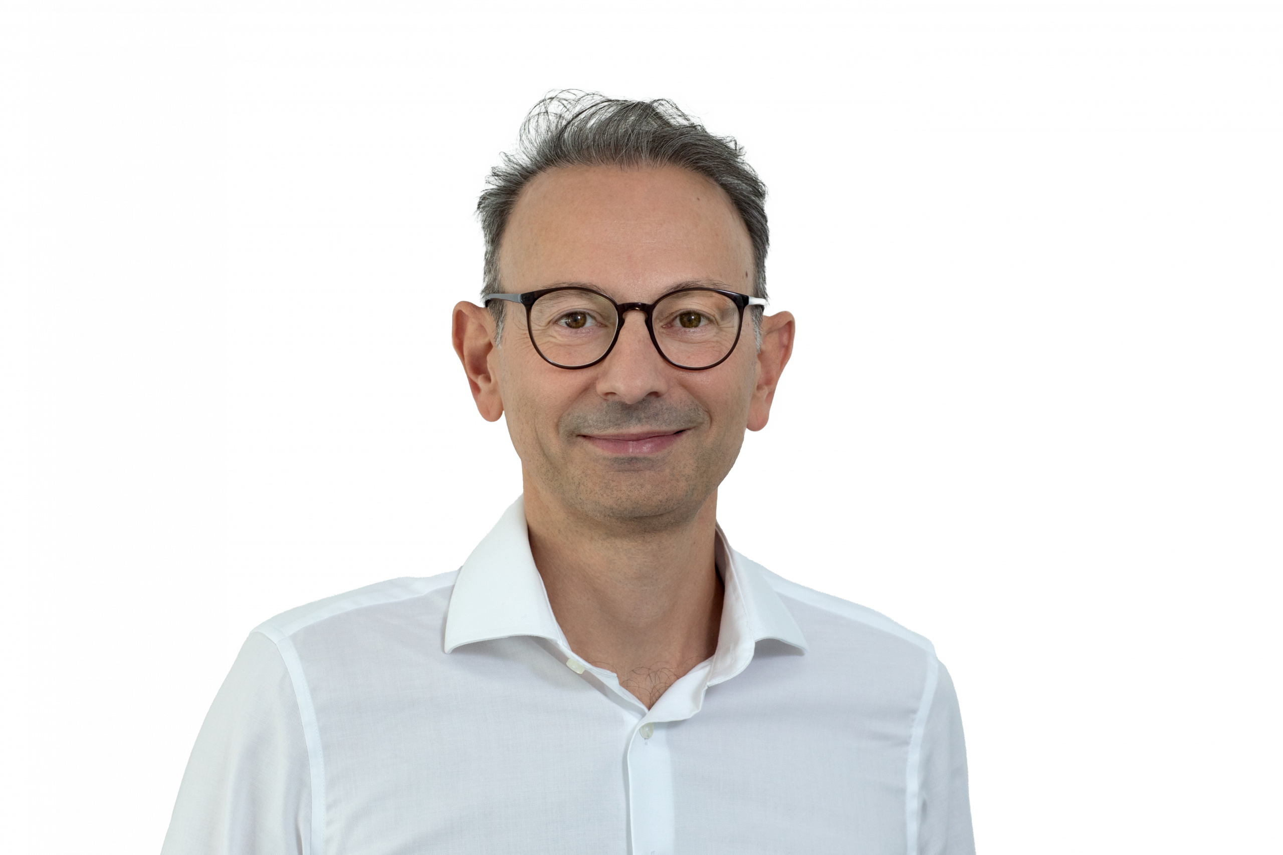 Porträt eines lächelnden Mannes mit Brille und weißem Hemd vor neutralem Hintergrund.