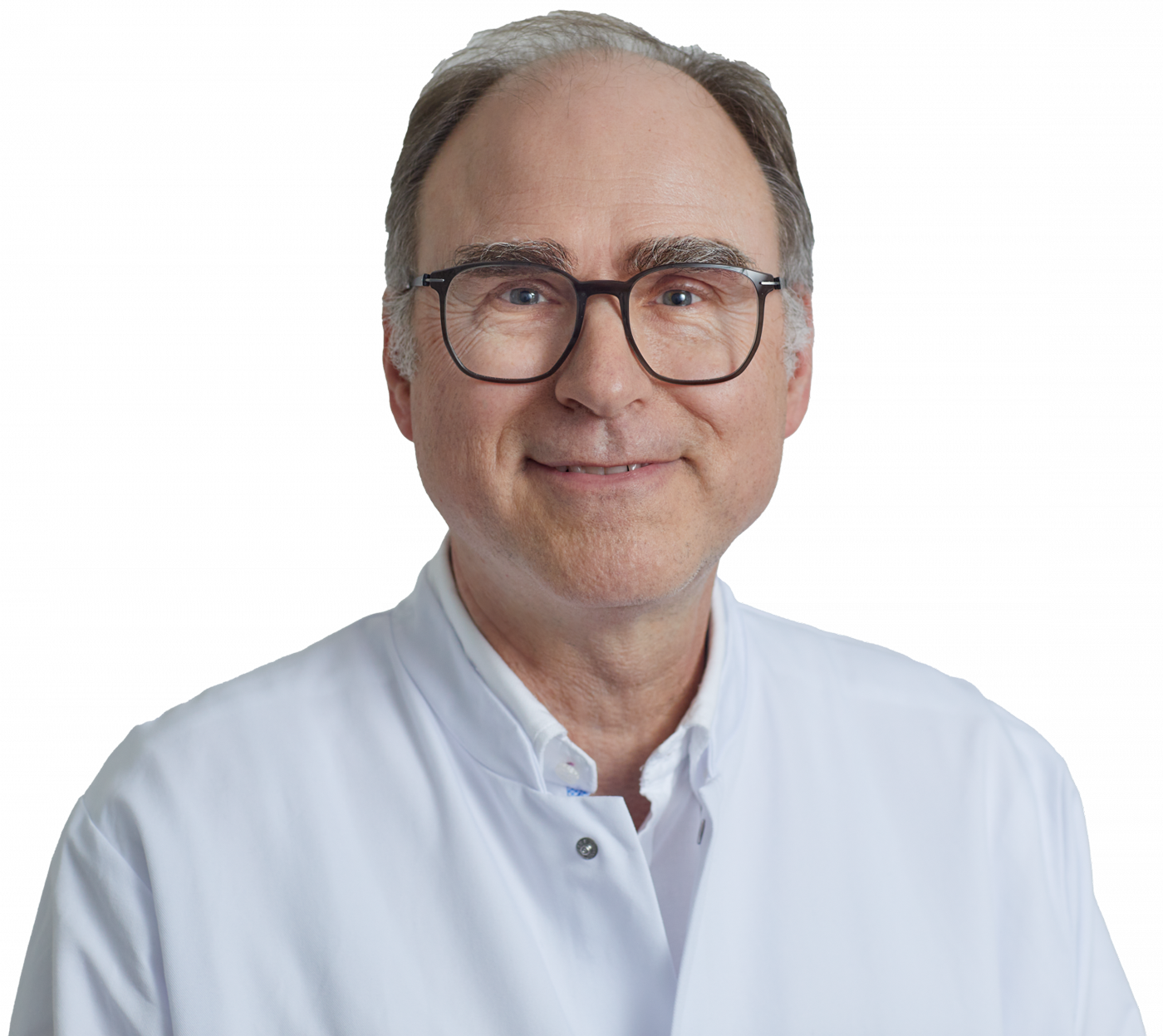 Ein lächelnder Mann in weißem Arztkittel und Brille, mit kurzem, grauem Haar, vor weißem Hintergrund.