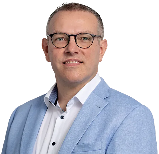 Ein Mann mit Brille und hellblauem Sakko vor grauem Hintergrund lächelt in die Kamera.