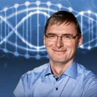 Mann in blauem Hemd vor einem stilisierten DNA-Hintergrund.