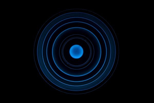 Blaue konzentrische Kreise auf schwarzem Hintergrund, die sich von einem zentralen Punkt aus erstrecken.