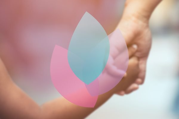 Kind und Erwachsene halten Händchen, beide tragen blau, verschwommener Hintergrund, rosa-blaues Logo in der Mitte.
