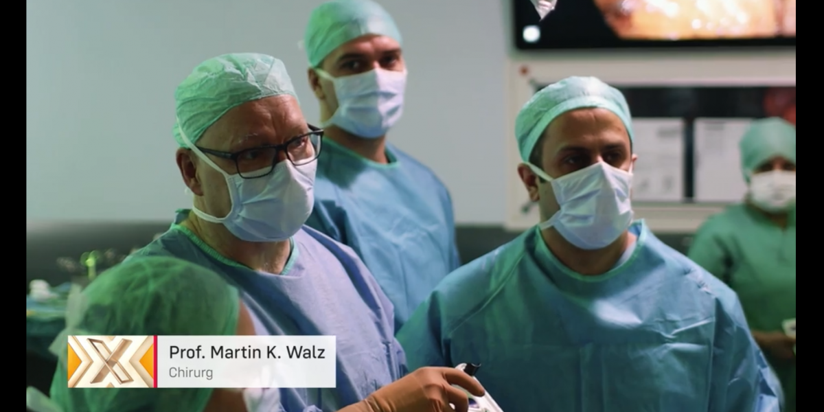 Ein Team von Chirurgen in OP-Kleidung und Masken arbeitet konzentriert im Operationssaal.